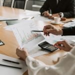 Professionals reviewing financial graphs and charts during a meeting. — Business Internships Abroad Trends Show Rising Demand