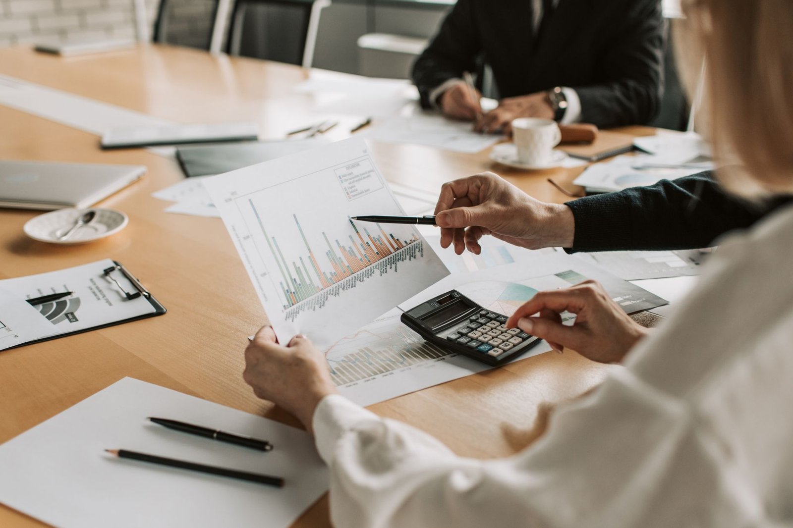 Professionals reviewing financial graphs and charts during a meeting. — Business Internships Abroad Trends Show Rising Demand